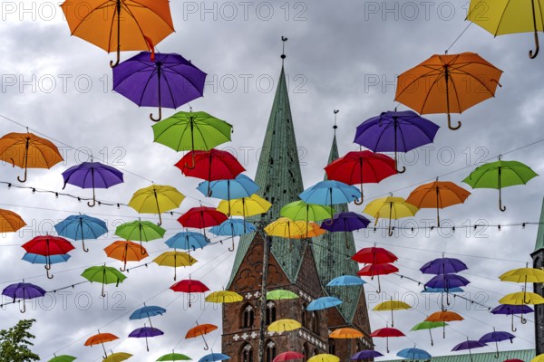 Colourful umbrellas for the HanseKulturFestival and the towers of St. Mary's Church, Hanseatic City of Lübeck, Schleswig-Holstein, Germany