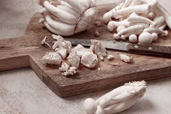 Freshly sliced Shimizhi mushrooms, on a wooden chopping board, ready to cook, close-up, no people