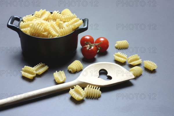 Italian pasta, 'Radiatori' variety, in pots and wooden spoon