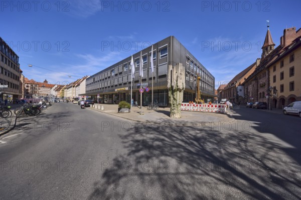 Commerzbank, modern architecture, stone fountain, fenced-off construction site, flags, flagpoles, blue sky, cirrostratus clouds, intersection Spitalgasse with Hans-Sachs-Platz, Nuremberg, Middle Franconia, independent city, Bavaria, Germany