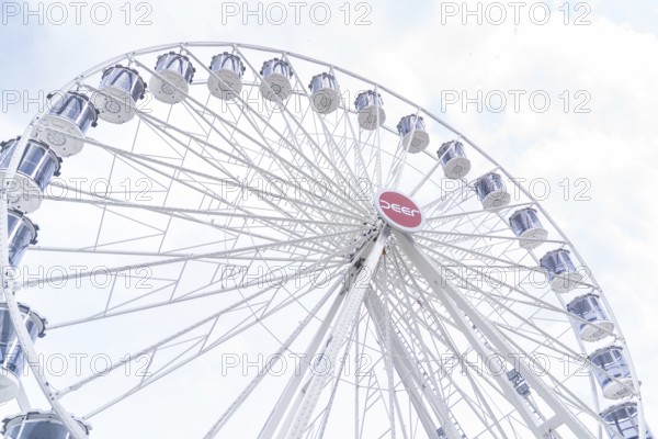 White Ferris wheel with distinctive gondolas in front of a slightly cloudy sky, Ferris wheel construction, Calw, Germany