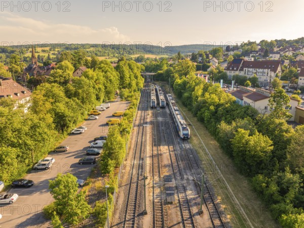 Aerial view shows railway tracks next to a car park and residential building, sunny summer atmosphere, Weil der Stadt railway station, Böblingen district, Germany