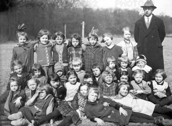 School outing girls class teacher, 1920, group of school children and a teacher outdoors with vintage atmosphere, historical photo