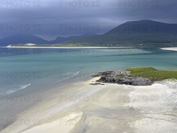 Dramatic sky over a calm beach with turquoise water and mountains in the background, Outer Hebrides, Isle of Harris, Scotland, United Kingdom