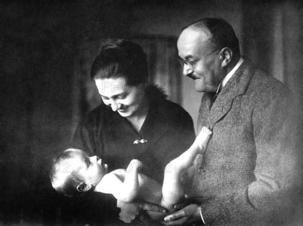 Parents with baby, 1930s, A couple smiling at a naked baby in their arms, Historical photo