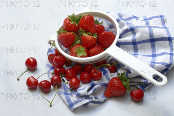 Cherries and strawberries in a colander, fruit