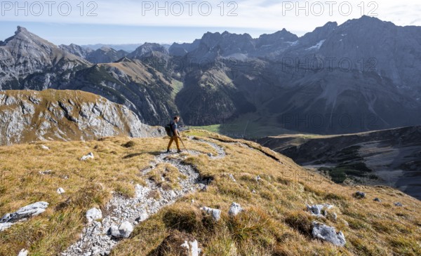Mountain panorama with picturesque mountain landscape, mountaineers descending from the Gamsjoch, behind mountain peaks Lamsenspitze and Sonnjoch, in autumn, Rißtal in the Eng, Karwendel, Tyrol, Austria