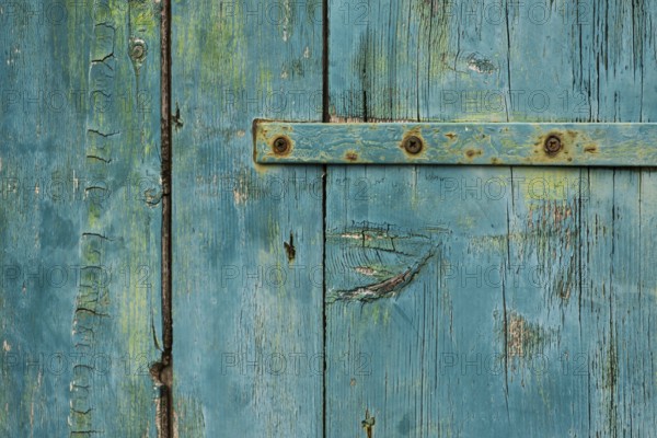 Weathered green wooden door with rusty metal accents in rustic style, background, texture, Montenegro, Balkans