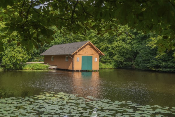 Boathouse at Meiereisee in Bürgerpark from 1866, landscape park with rivers and lakes, garden monument, attraction, recreation, groups of trees, nature, water reflection, water lilies, city state of Bremen, Germany
