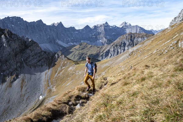 Mountaineers on a hiking trail at the Gamsjoch, picturesque mountain landscape in autumn, view of the rocky mountain ridge of the Hinterautal-Vomper chain, Rißtal in the Eng, Karwendel, Tyrol, Austria
