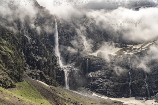 Waterfall in the cloudy Cirque de Gavarnie basin, UNESCO World Heritage Site in the Pyrenees National Park near Gavarnie-Gèdre, France