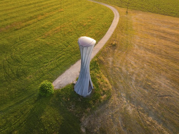 Modern building on a field with a curved path in the evening light