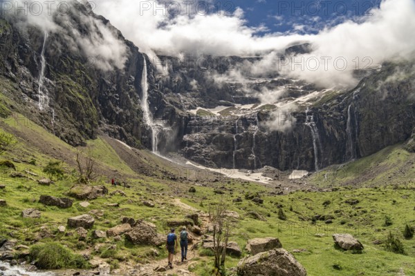 Hikers in the cloudy Cirque de Gavarnie basin, UNESCO World Heritage Site in the Pyrenees National Park near Gavarnie-Gèdre, France