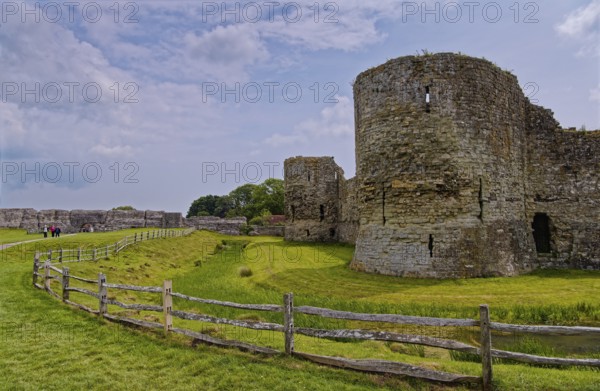 Wall and moat of Pevensey Castle, a Norman castle, in the village of Pevensey, Sussex, England, United Kingdom