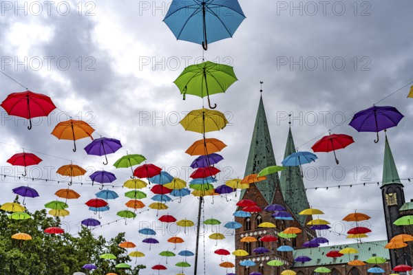 Colourful umbrellas for the HanseKulturFestival and the towers of St. Mary's Church, Hanseatic City of Lübeck, Schleswig-Holstein, Germany