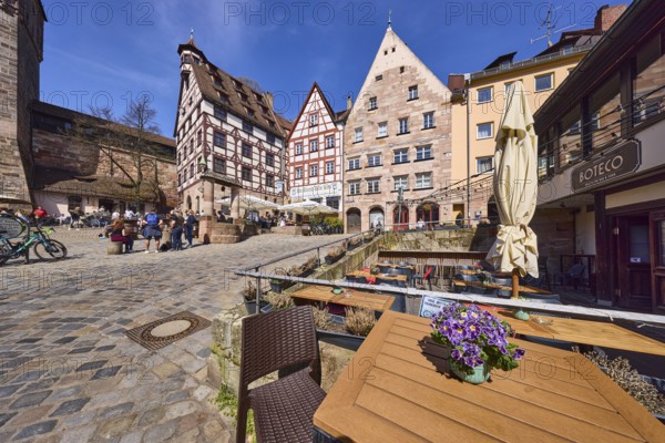 Pilatushaus, town house, late Gothic architectural style, historic buildings, half-timbered houses, cobblestones, outdoor area of a restaurant with tables, chairs and parasol, square, pedestrians as secondary motif, super wide angle, blue sky, Beim Tiergärtnertor, Obere Schmiedgasse, Tiergärtnertorplatz, cirrostratus clouds, Nuremberg, Middle Franconia, independent city, Bavaria, Germany