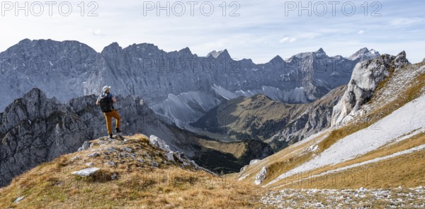 Mountaineers in front of a picturesque mountain landscape in autumn, view of the rocky ridge of the Hinterautal-Vomper chain, Rißtal in the Eng, Karwendel, Tyrol, Austria