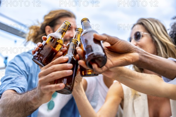 Group of friends celebrating on a rooftop, raising their beer bottles high for a joyful toast, embodying happiness and togetherness