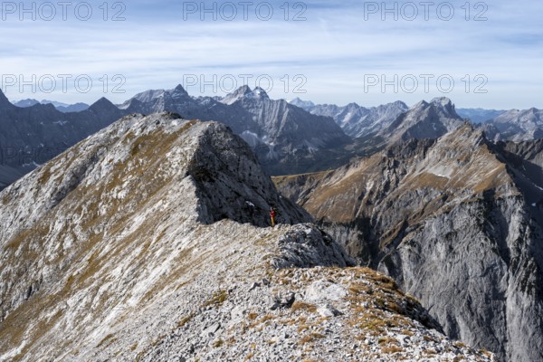 Mountain panorama, mountaineer on the ridge of the Gamsjoch, transition to the main summit of the Gamsjoch, behind western summit with summit cross, behind mountain ridge of the Hinterautal-Vomper chain, in autumn, Rißtal in the Eng, Karwendel, Tyrol, Austria