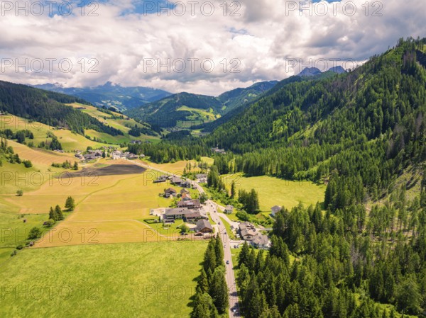 Expansive aerial view of a green valley with mountains and dense forests