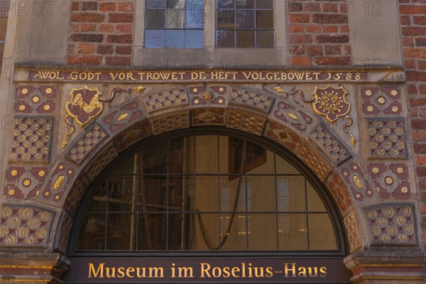 Entrance to the museum in the Roselius House in Böttcherstrasse, cultural monument, historic city centre, gilded inscription and ornamentation, He who trusts God has built well, year 1588, red brick building, sight, tourist attraction, pedestrian zone, Hanseatic city of Bremen, Germany