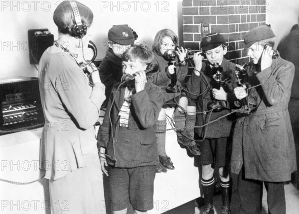 Children experimenting with telecommunication, group of children with telephones in a historical setting, historical photo