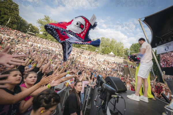 Eisbären Berlin players throw scarves and other fan merchandise into the audience at the Berliner Rundfunk 91.4 Open Air at the Berlin Parkbühne Wuhlheide on 5 July 2025
