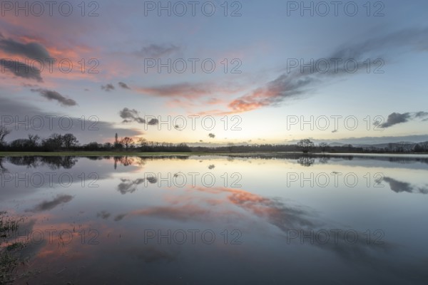 De ondergang van de zon kleurt de lucht in prachtige tinten, terwijl het meer de reflectie van de wolken en het licht laat zien. A calm and noble environment