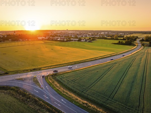 View of cars on a road next to fields at sunset, wide and peaceful scene, Renningen, Germany