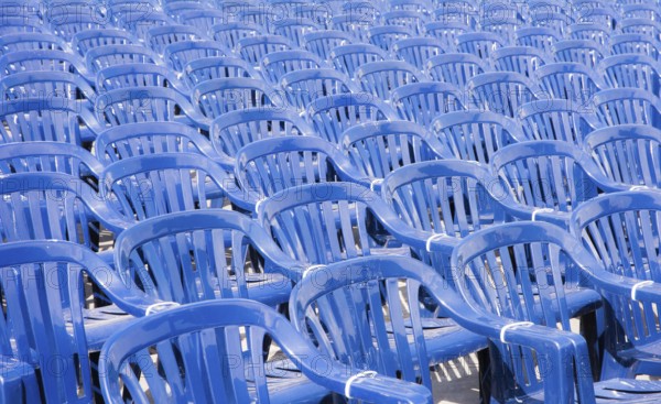 Many rows with a lot of blue pastic chairs