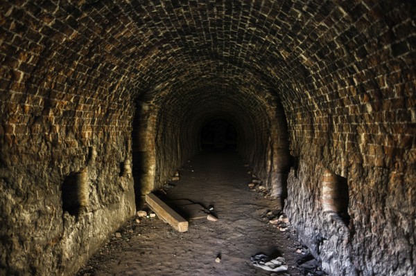 Grunge, spooky arched corridor in an abandoned brick building, urban exploration, haunted tunnel scary looking place