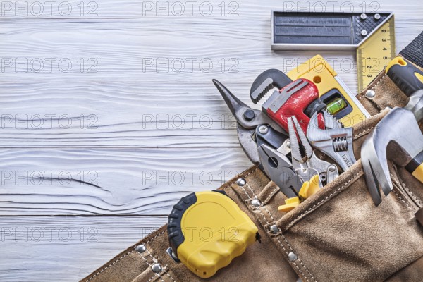 Construction of tools in a tool belt on a wooden board Construction concept