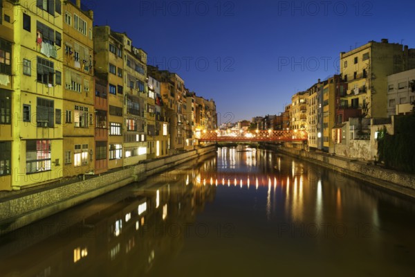Girona city by night in Spain, waterside houses on the River Onyar, picturesque urban landscape in Catalonia region