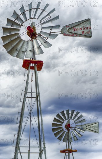 A vertical view of two wind wheels or wind pumps up close