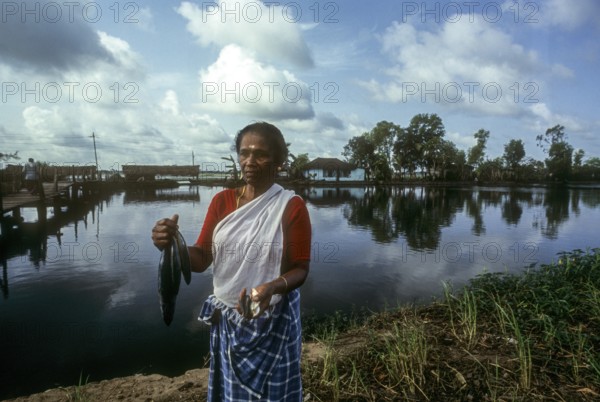 A woman holding freshly caught fish, Backwaters of Kerala, South India, India, Asia