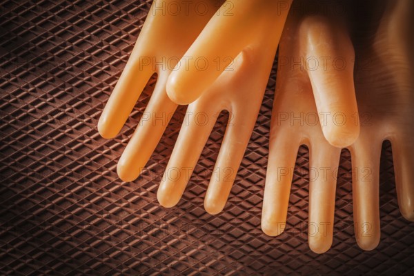 A pair of insulating gloves on a dielectric rubber mat