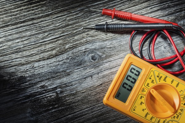 Electric multitester on wooden board