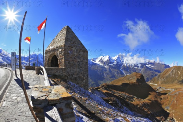 Steep turns are marked with red flags. Picturesque alpine road Grossglocknershtrasse. Bright sunny day. Photo taken by lens Fisheye