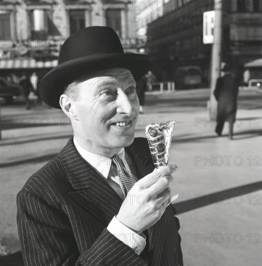 Ice cream in the 1960s. A well dressed gentleman in a suit and hat enjoys a ice cream on a sunny day. Sweden 1965 Kristoffersson ref CN4-6