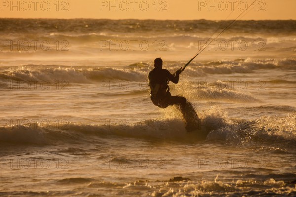 Single surfer at sunset on a calm ocean