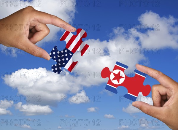Two hands each holding a puzzle piece, silhouette, confrontation, rapprochement, war, trade war, economic war, nuclear treaty, great powers, USA, North Korea, disarmament, nuclear weapons