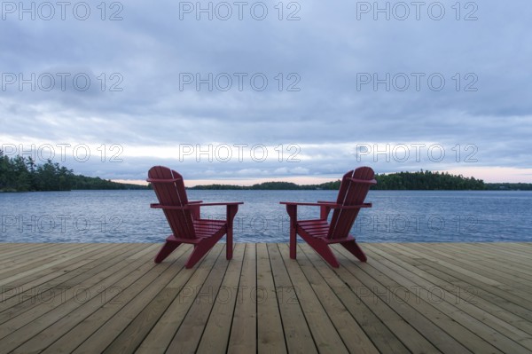 Known as Muskoka or Adirondack chairs sit on a dock at a resort in Muskoka, Ontario, Canada, North America