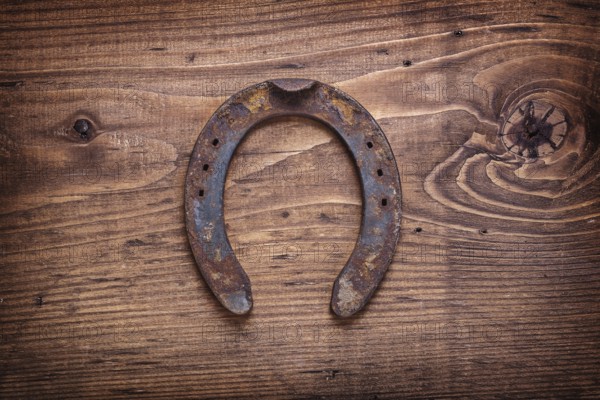 Single old horseshoe on vintage wooden board happy concept