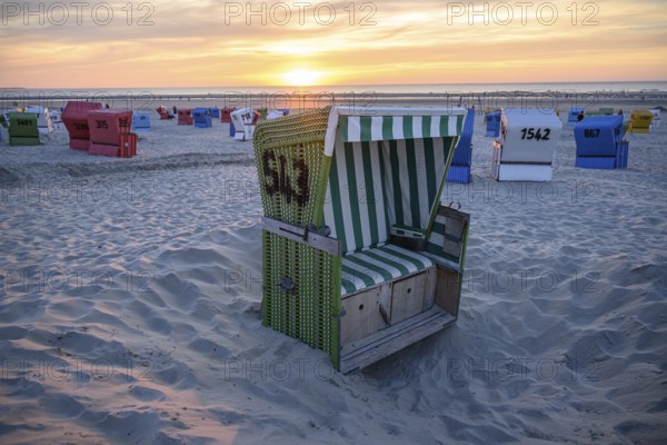 Single green beach chair on the beach at sunset with sea view, langeoog, east frisia, germany