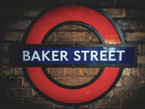 The iconic round sign of Baker Street Underground Station on a brick wall Baker Street Underground Station, London NW1 5BF, England, United Kingdom