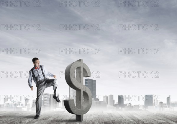 Determined banker man against modern cityscape breaking dollar cement figure