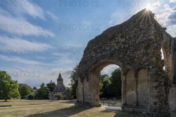 Glastonbury, United Kingdom, 1 September, 2022: view of the ruins of the Choir at the Glastonbury Abbey with a sunburst in the corner