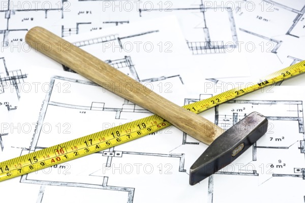 Hammer and yardstick lying on construction plan