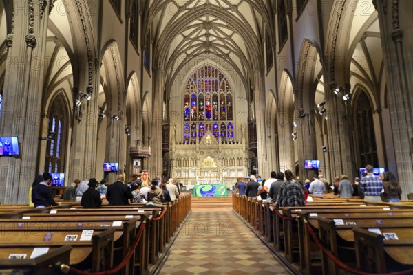 Manhattan, New York City, New York, USA, North America, Interior view of the majestic Trinity Church with gothic windows and pews, Interior view of a church with high gothic arches and people on pews, United States of America
