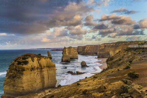 Travel to Australia. Pink dawn clouds over the rocks Twelve Apostles. Early morning on the ocean shore. The concept of active, ecological and photo tourism